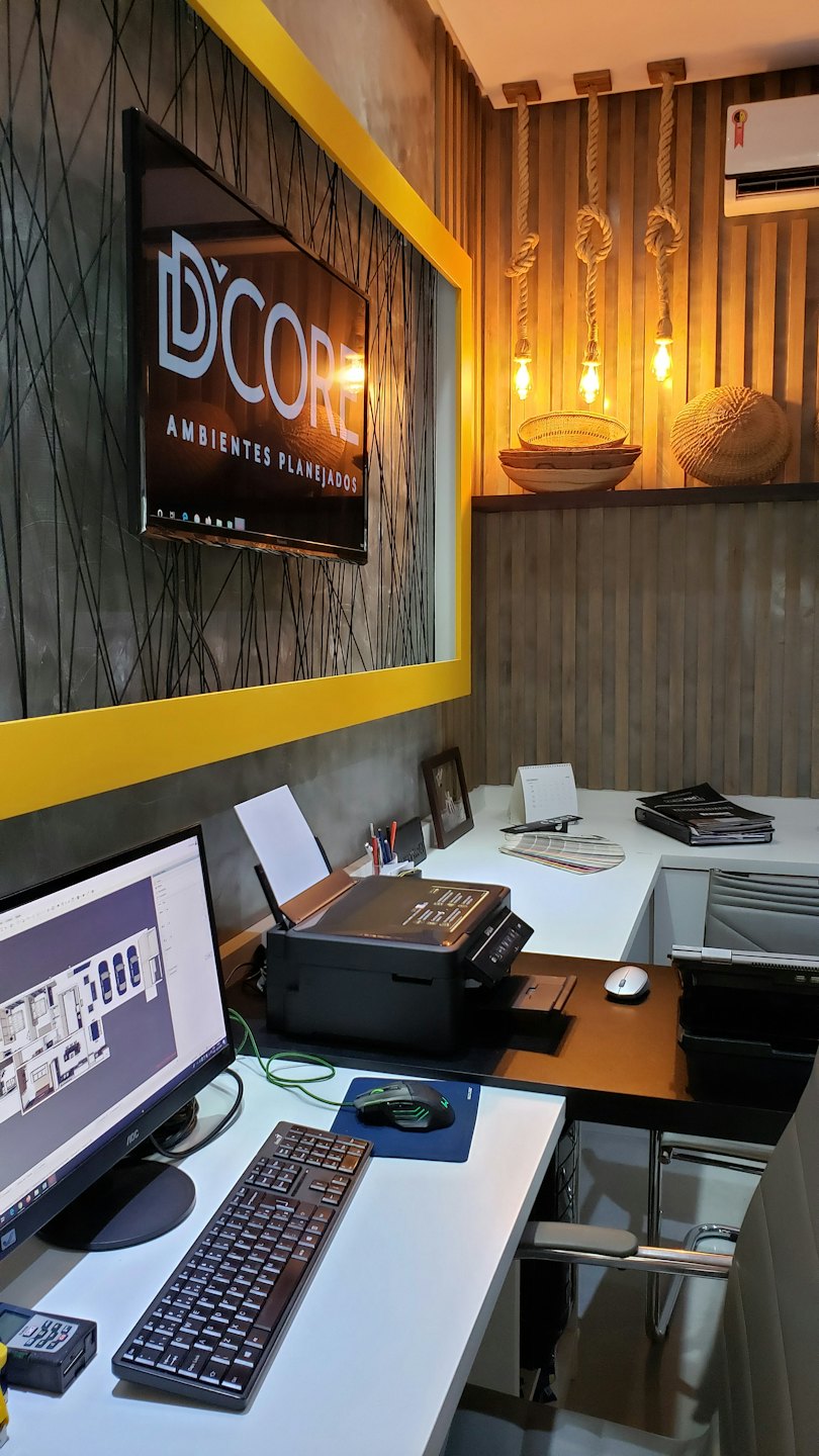 Modernes Büro mit Schreibtischen, Computern, die Grundrisse und das D'CORE-Logo anzeigen.
